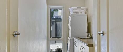 Un pasillo estrecho con una puerta que da a un área de lavandería.
