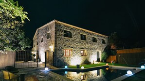 A stone building with a swimming pool, outdoor seating, and a well-lit entrance. - Private villa for 20 guest, boutique hotel style! (Rubió)