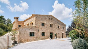A stone building with multiple windows and a central entrance. - Private villa for 20 guest, boutique hotel style! (Rubió)