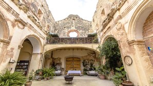 An interior courtyard with arches, a wooden table, and potted plants. - Breathtaking 18th Century Converted Convent! (Vila-Rodona)