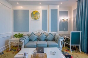 Una habitación con un sofá azul claro, una mesa de centro blanca y un cuadro decorativo en la pared.