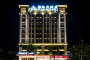 Un hotel de varios pisos con señalización iluminada y una entrada destacada.