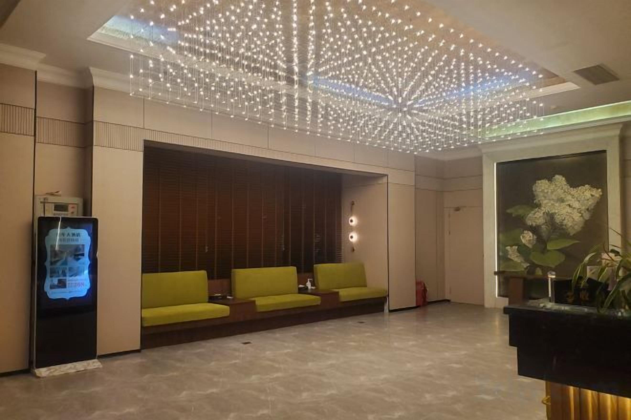 A lobby with a seating area, a reception desk, and a decorative ceiling.