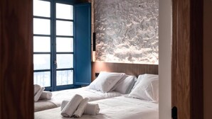 Une chambre d’hôtel avec deux lits, une grande fenêtre et une vue sur un paysage enneigé.