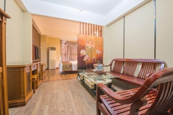 A living room with a sofa, a glass coffee table, and wooden furniture. - Junyi Hotel (Fuzhou Dongjiekou Metro Station, Sanfang Qixiang) (Fuzhou)