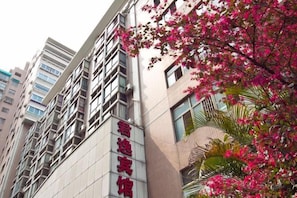 A multi-story building with a modern architectural design, featuring a prominent entrance and signage. - Junyi Hotel (Fuzhou Dongjiekou Metro Station, Sanfang Qixiang) (Fuzhou)