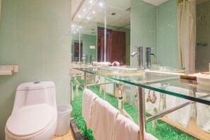 Ein Badezimmer mit einem Tresenspiegel, Toilette und Duschbereich.