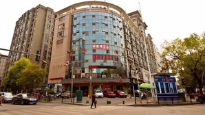 Un immeuble à plusieurs étages doté d’une façade incurvée, caractérisé par un mélange de verre et de béton.