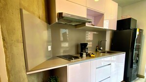 Eine moderne Küche mit weißen Schränken, einem schwarzen Kühlschrank und einem eingebauten Backofen.