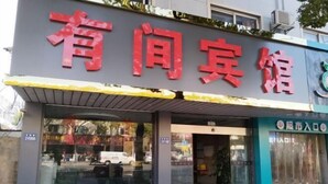 A hotel entrance with a large red sign, a glass door, and a small awning. - Kunshan Youjian Hotel (Huaqiao Huaxi Park Subway Station) (Kunshan)