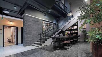 Ein modernes Interieur mit einer Treppe, einem Essbereich und einem Bücherregal.