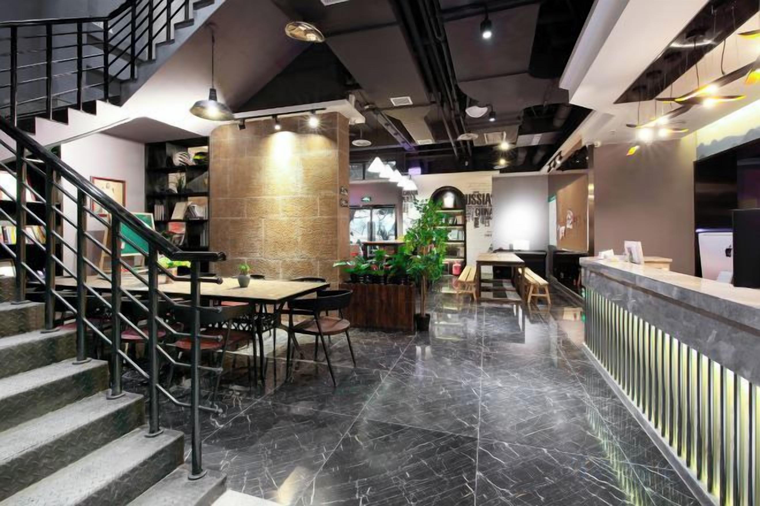 A modern interior with a reception desk, seating area, and a staircase.