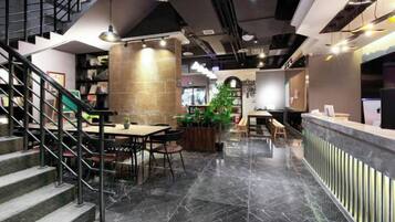A modern interior with a reception desk, seating area, and a staircase.