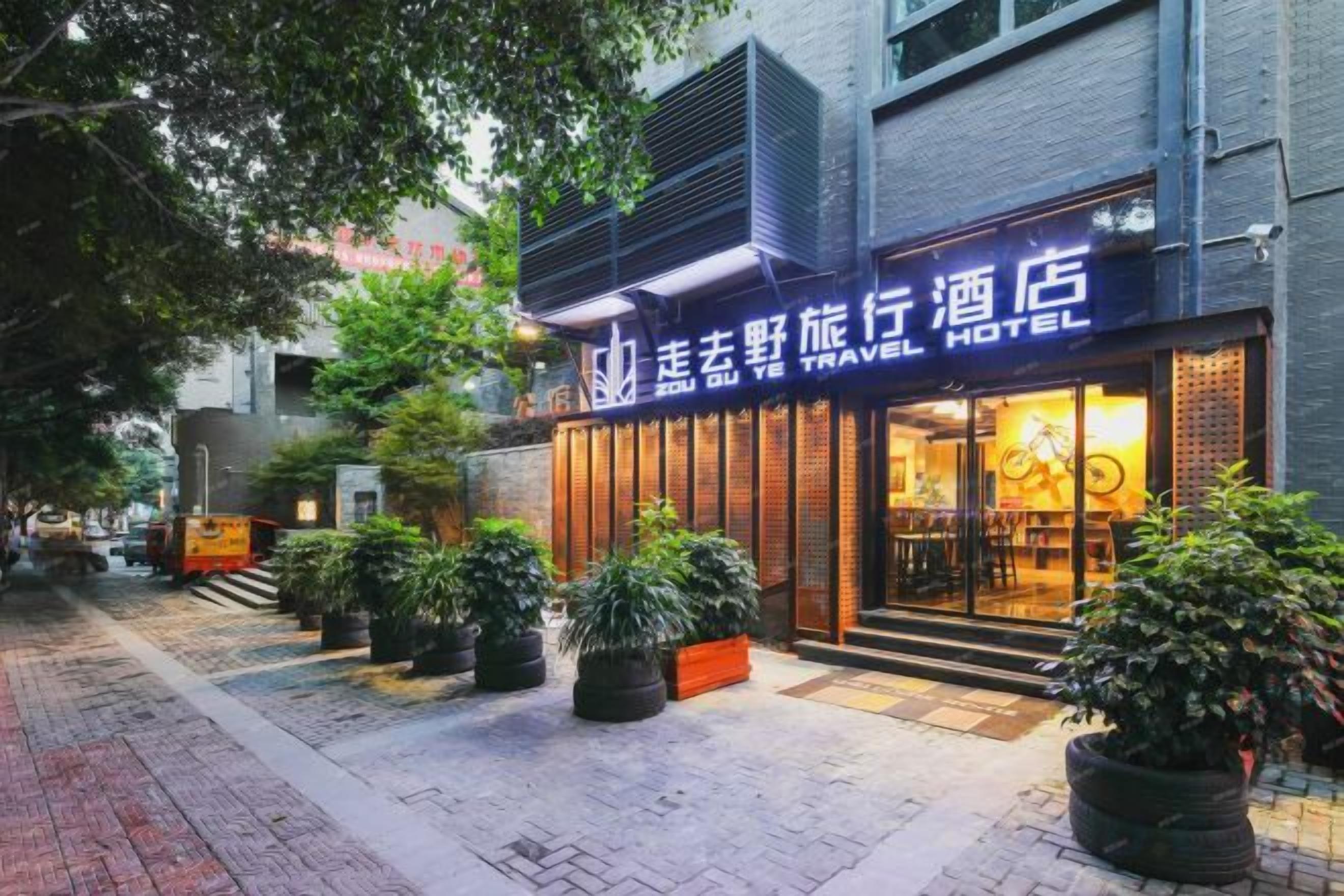 Un hotel para viajeros con fachada moderna, amplios ventanales y zona de estar al aire libre.