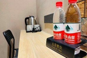 A table with two bottles of water and a black stand with text. - Zou Qu Ye Travel Hotel (Chongqing)