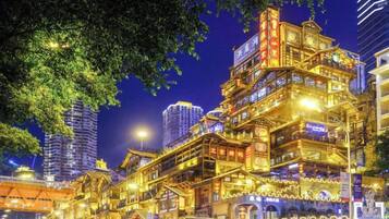 Un edificio de varios pisos con elementos arquitectónicos tradicionales, iluminado durante la noche.
