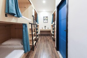 A narrow corridor with bunk beds on either side, a small kitchenette area, and a blue door on the right. - Zou Qu Ye Travel Hotel (Chongqing)