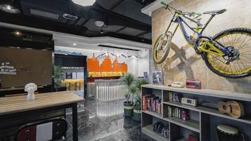 Un interior moderno con mostrador de recepción, zona de estar y una bicicleta fijada a la pared.
