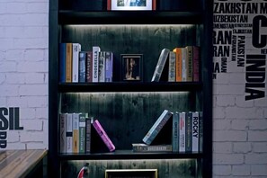 Una estantería con libros y un cuadro enmarcado.