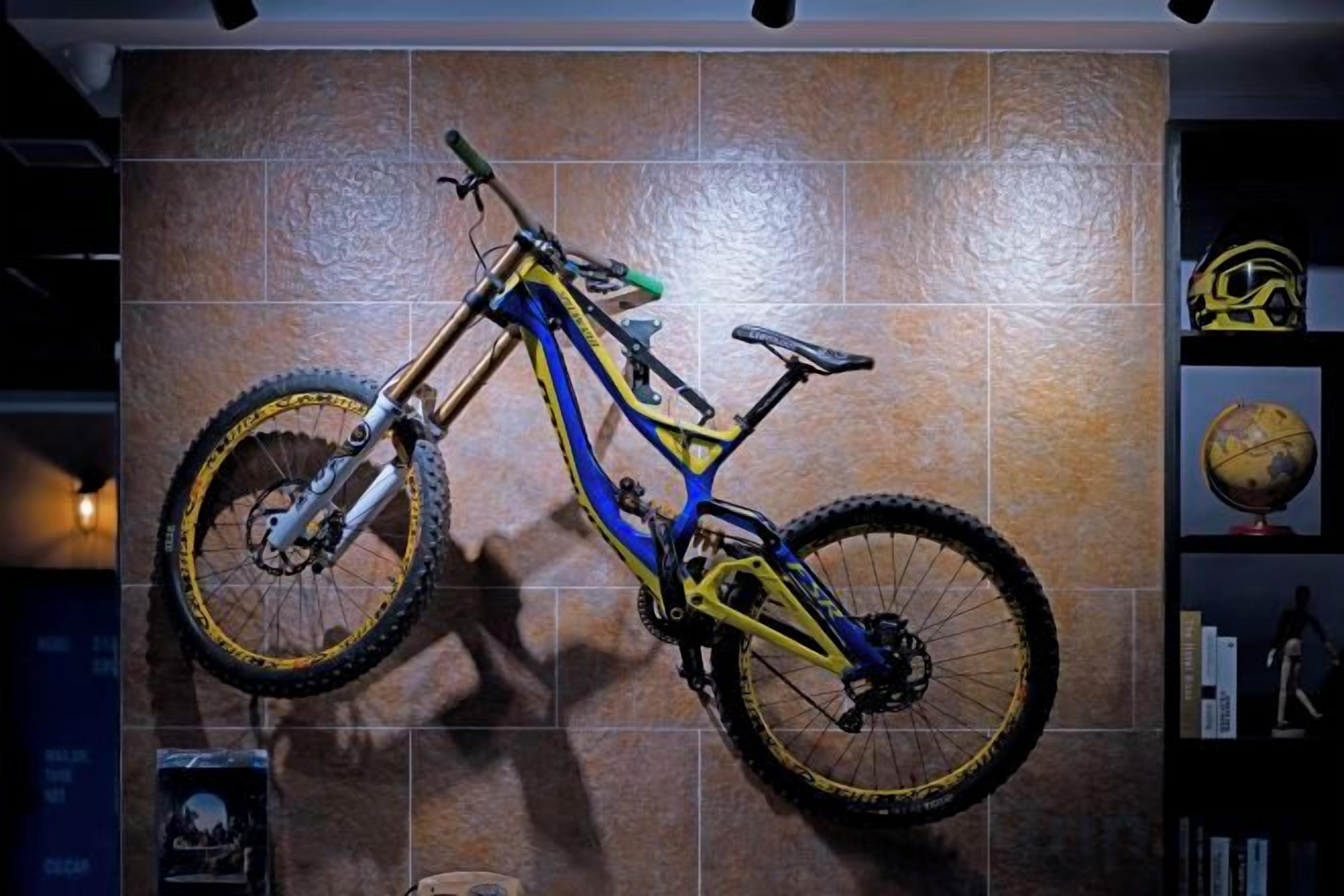 A mountain bike mounted on a wall with a tiled background.
