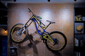 A mountain bike mounted on a wall with a tiled background.