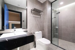 A modern bathroom with a black marble sink, white toilet, and a glass shower enclosure. - Zou Qu Ye Travel Hotel (Chongqing)
