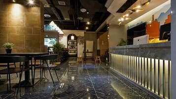Ein modernes Interieur mit einer Rezeption, einer Sitzecke und einer Treppe.