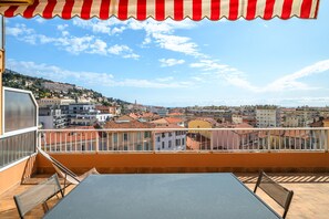 Enjoy the city view from this balcony with a table and chairs, perfect for taking in the sights.