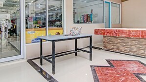A modern interior with a glass storefront, a black metal table, and a red and black patterned floor. - Hotel O Penginapan Thoybah Syariah Near Pondok Pesantren UMAR BIN KHATAB km 9 garuda sakti (Pekanbaru)