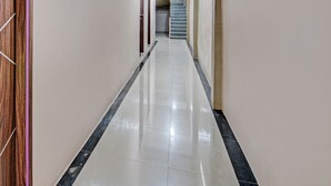 A long, narrow hallway with a polished floor, leading to a staircase. - Hotel O Penginapan Thoybah Syariah Near Pondok Pesantren UMAR BIN KHATAB km 9 garuda sakti (Pekanbaru)