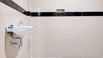 Habitación estándar doble | Baño | Ducha, cabezal de ducha tipo lluvia, toallas y papel higiénico