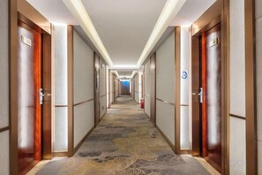A hotel corridor with doors on both sides, a patterned carpet, and a blue sign on the right wall. - Jade Business Hotel (Jade Street, Pingzhou, Foshan) (Foshan)
