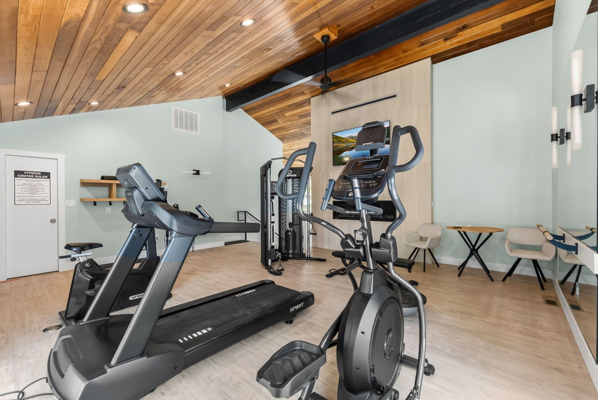 Ein Fitnessstudio mit Laufbändern, Crosstrainern und einem Ergometer.