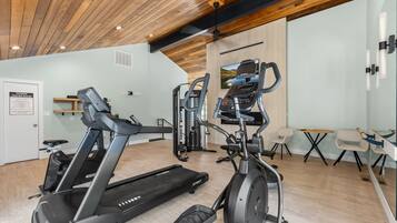 Ein Fitnessstudio mit Laufbändern, Crosstrainern und einem Ergometer.