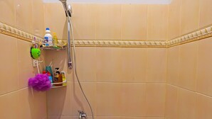 A small bathroom with a shower, a toilet, and a blue bucket. - Hotel O Kurnia ShangrilaNearNagoya Hill Shopping Mall (Batam)