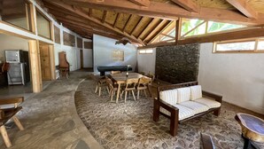 A rustic interior with a stone floor, wooden furniture, and a stone wall. - Cabañas los Pirineos (Mazamitla)