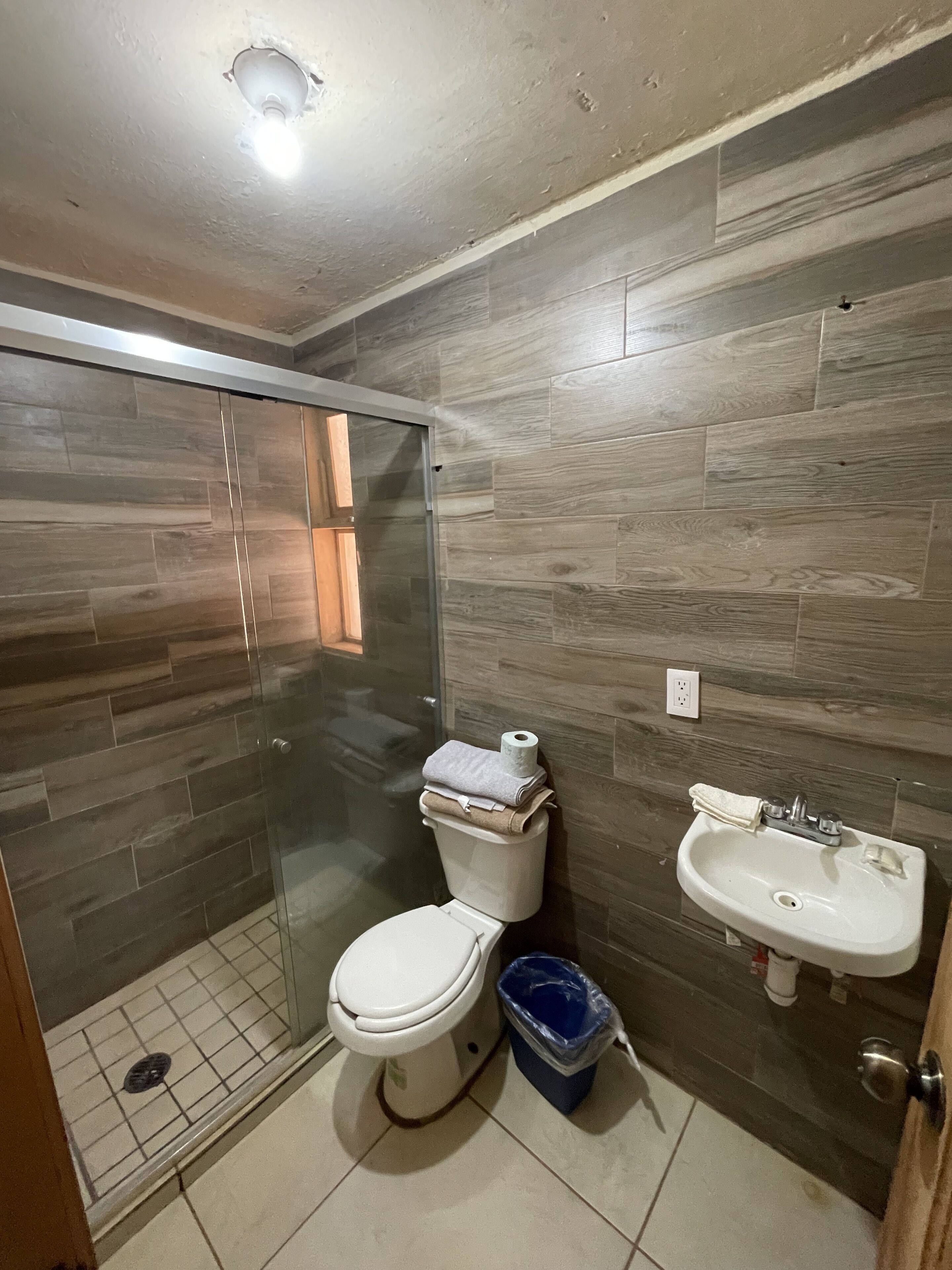 Une salle de bain comprenant des toilettes, un lavabo et un espace douche.