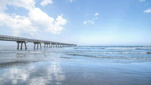Eine Pier, die sich in ruhiges Wasser erstreckt, mit einem wolkenlosen Himmel darüber.