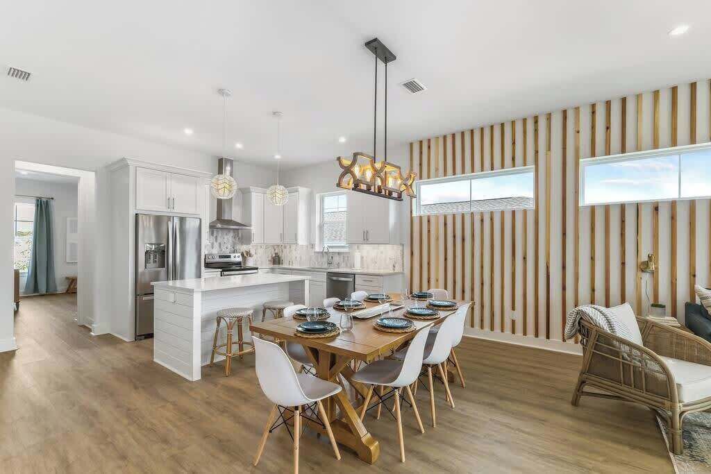 Una cocina moderna con armarios blancos, electrodomésticos de acero inoxidable y una isla central.