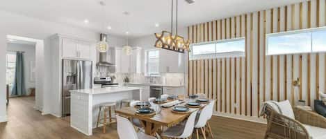 A modern kitchen with white cabinets, stainless steel appliances, and a central island.
