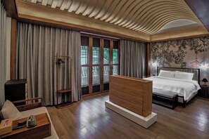 A modern bedroom with a wooden bed, a nightstand, and a large window with curtains. - Xiuhe Hot Spring Holiday Hotel (Xiushui)