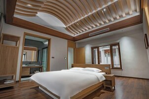 Un dormitorio moderno con una cama de madera, armario empotrado y un espejo grande.
