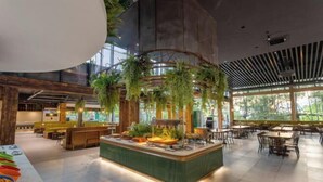 A spacious indoor area with a central island, seating arrangements, and large windows allowing natural light. - Xiuhe Hot Spring Holiday Hotel (Xiushui)