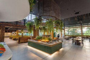 A spacious indoor area with a central island, seating arrangements, and large windows allowing natural light. - Xiuhe Hot Spring Holiday Hotel (Xiushui)