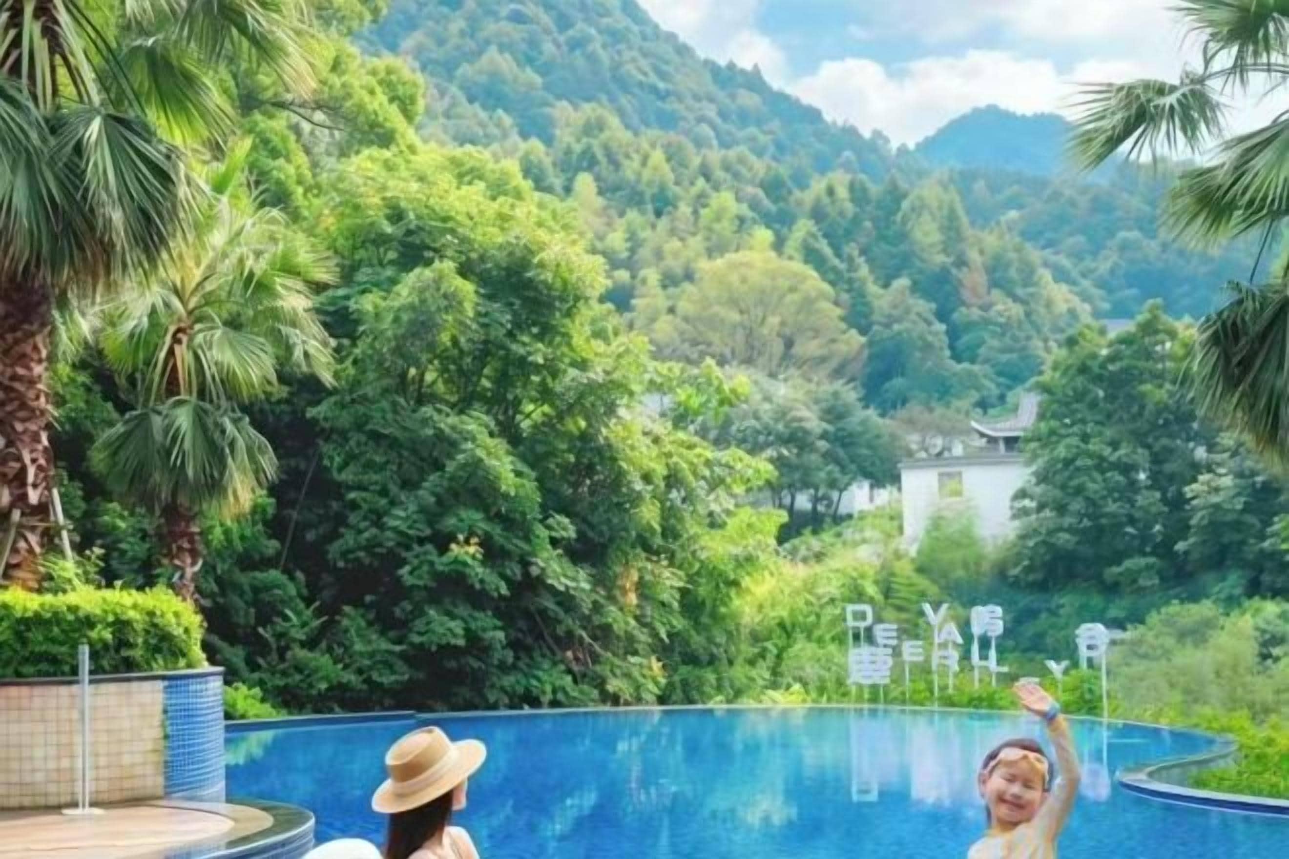 A swimming pool with a view of a mountainous landscape and a traditional building in the background.