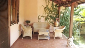 A covered patio area with wicker furniture, a potted plant, and a decorative vase. - Villa with garden - Porto Ada Pizzo - (Pizzo Calabro)