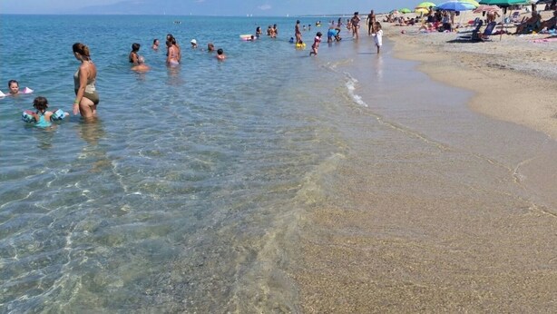 A beach with clear shallow waters, people swimming and sunbathing, and umbrellas on the sand. - Villa with garden - Porto Ada Pizzo - (Pizzo Calabro)