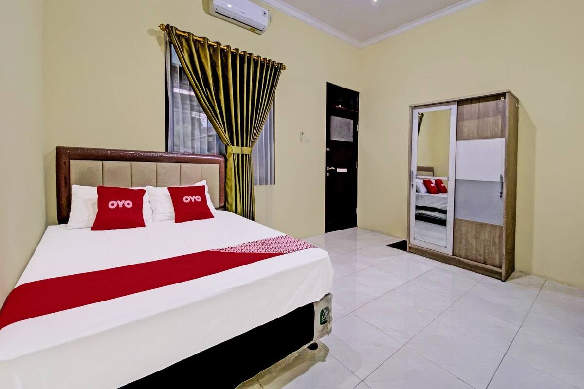 Een hotelkamer met een bed, een kledingkast en een deur.