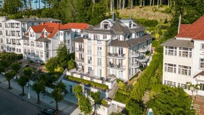 Ein mehrstöckiges Hotel mit Balkonen, einem Innenhof und Blick auf die umliegende Natur.