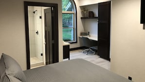 Une chambre à coucher avec un lit, un bureau et une douche.